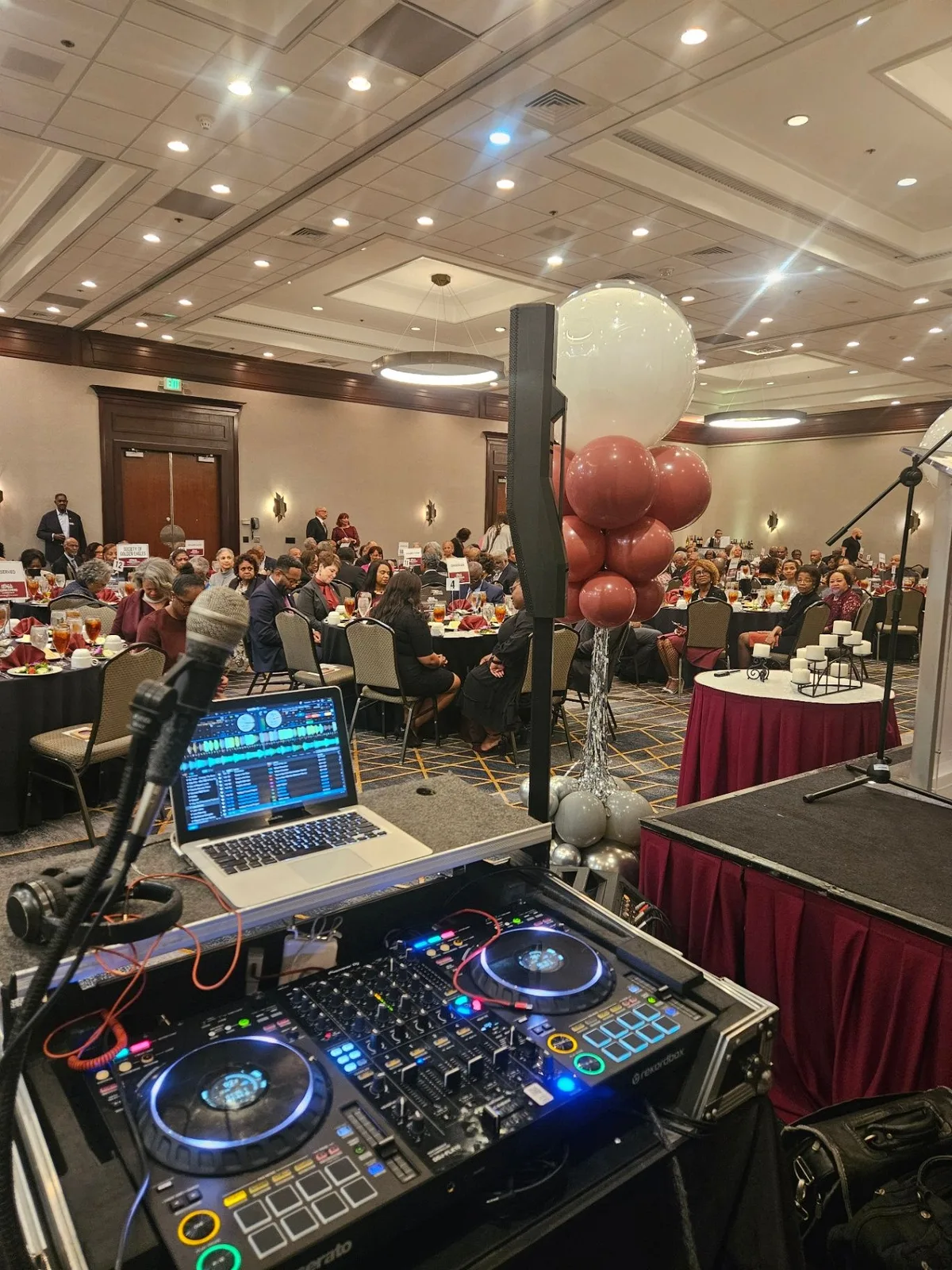 DJ setup facing a seated audience at a formal event